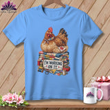 Light blue t-shirt with a hen sitting on quilts, reading 