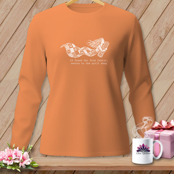 Orange long-sleeve shirt with white graphic of a woman and quilt fabric.