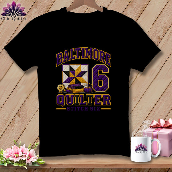 A black t-shirt with a "Baltimore Quilter Stitch Six" graphic and a quilt block design.