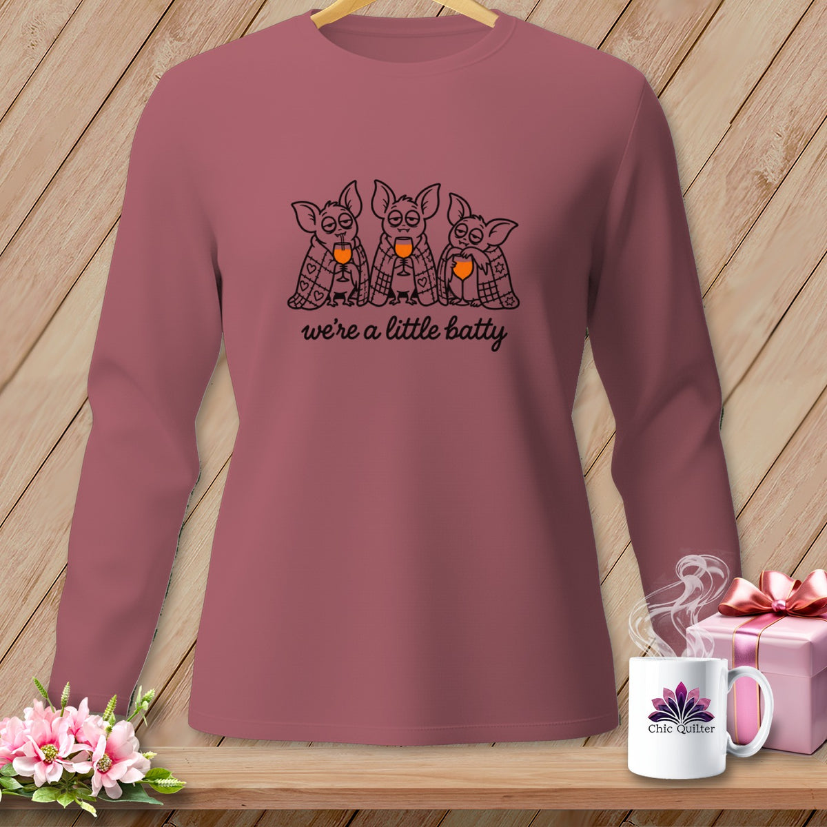 Rose long-sleeved shirt with three cartoon bats and the text "we're a little batty".