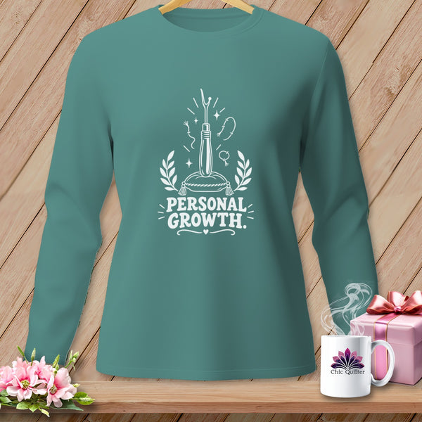 Teal long-sleeve shirt with "Personal Growth" text and sewing-themed graphics.