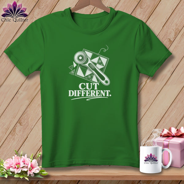 Green t-shirt with white graphic of a rotary cutter and fabric, reading "CUT DIFFERENT."