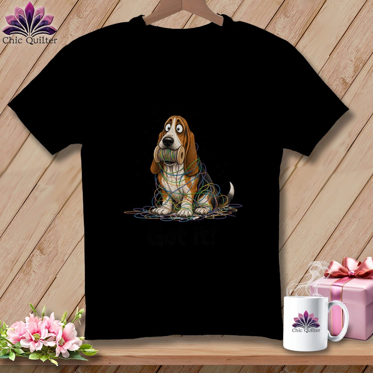 Black t-shirt with a cartoon basset hound tangled in colorful thread.