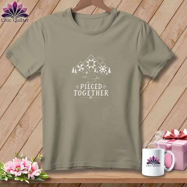 Tan t-shirt with white mountain, quilt, sun, and "Pieced Together" text design.