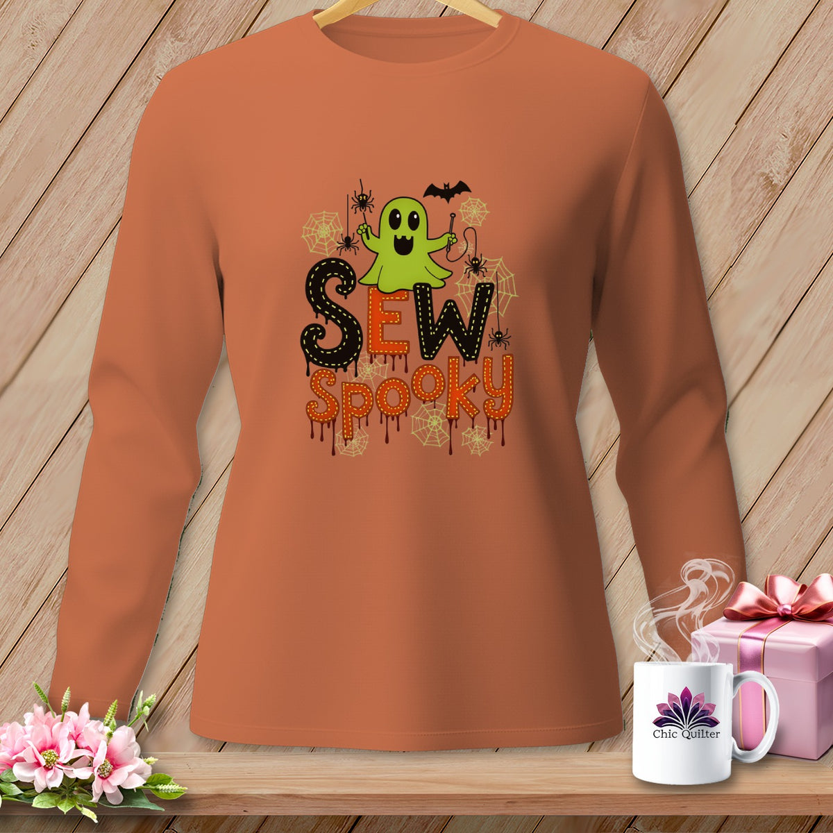 Orange long-sleeve shirt with a green ghost, spiders, and "Sew Spooky" text.