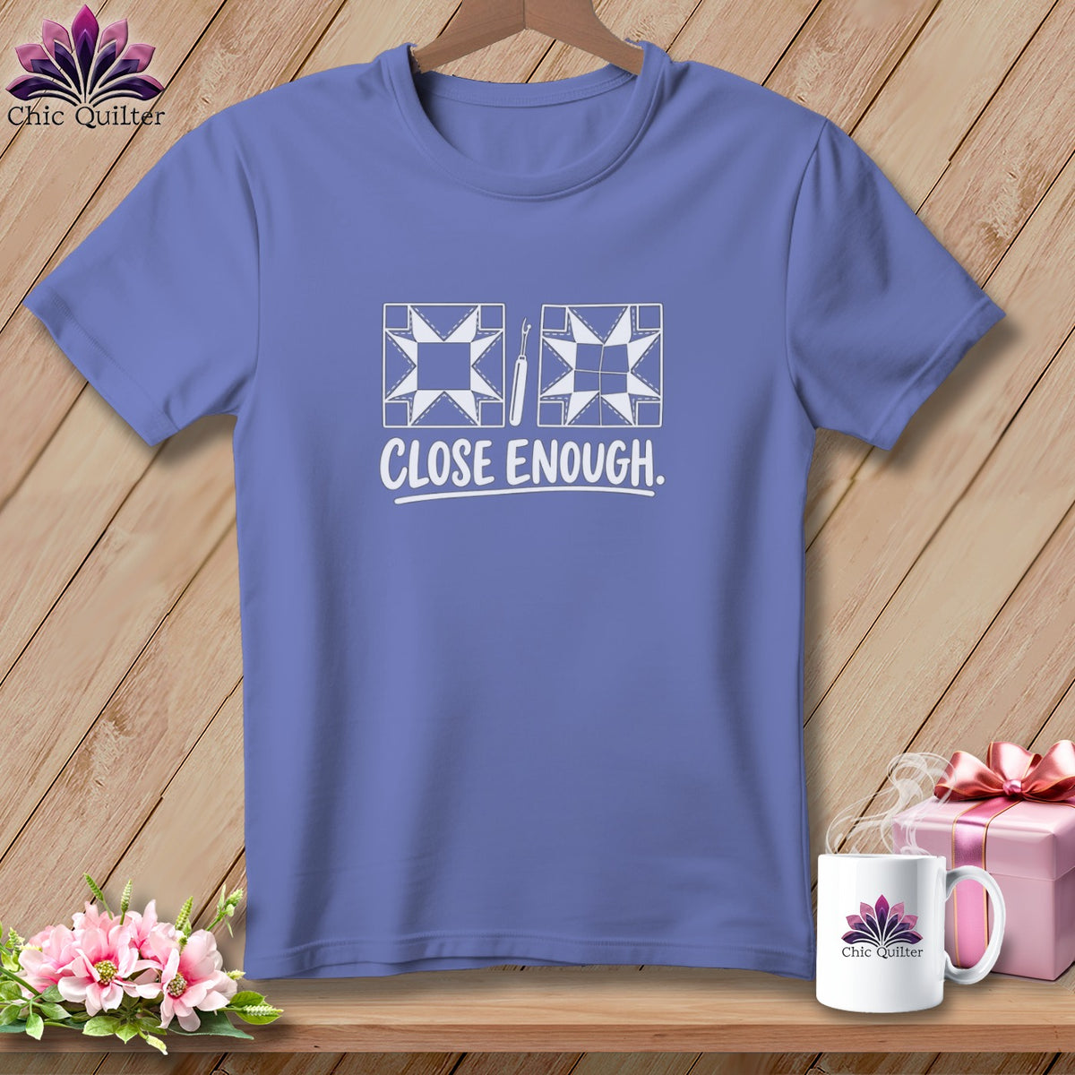 Purple t-shirt with quilting block and seam ripper graphic and "CLOSE ENOUGH." text.