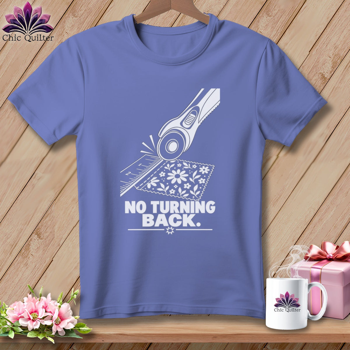 Purple t-shirt with white graphic of rotary cutter, ruler, fabric, and text "NO TURNING BACK."