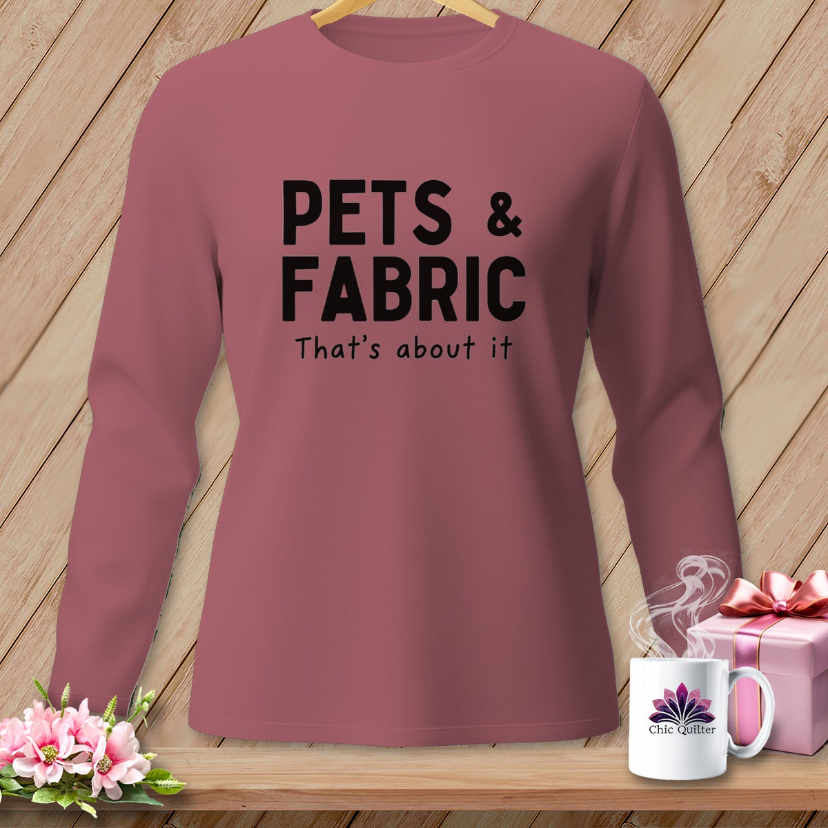 Pink long-sleeve shirt with black text "PETS & FABRIC That's about it".