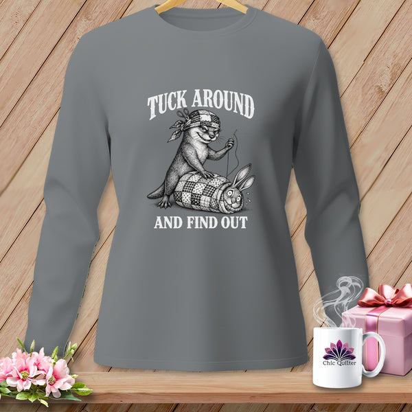 Charcoal long-sleeve shirt featuring an otter sewing a rabbit into a quilt, with text that reads Tuck Around And Find Out.