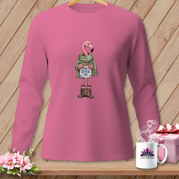Pink long-sleeve shirt with a flamingo wearing a scarf and boots holding a gift.
