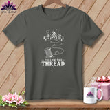 Dark gray t-shirt with a white graphic of a spool of thread and mountains, text 
