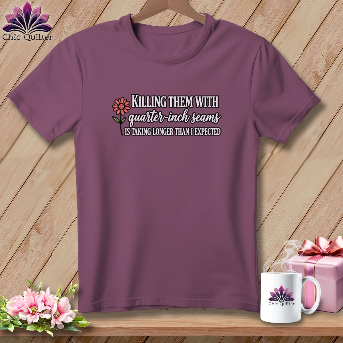 Plum t-shirt with quilting graphic text and flower, alongside a mug and gift box.