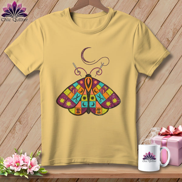 Yellow t-shirt with a colorful quilt-patterned moth graphic and sewing details.