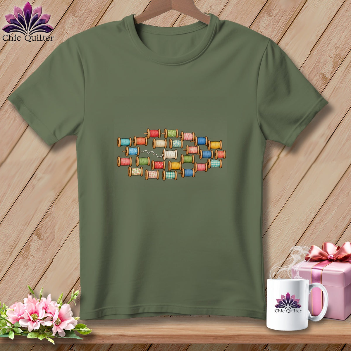 An olive green t-shirt with a graphic of colorful thread spools on the chest.