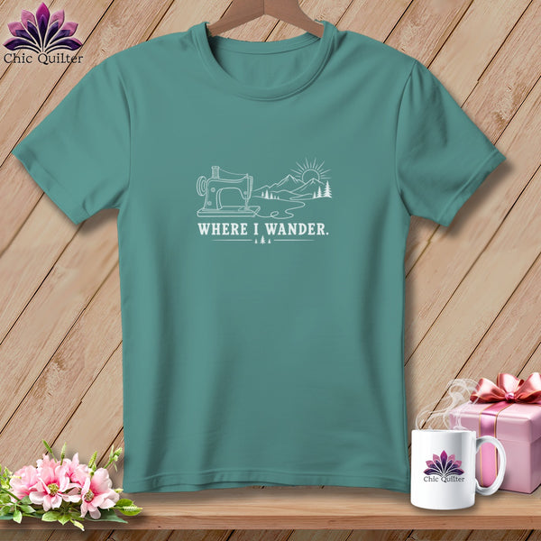 Teal t-shirt with white line art of sewing machine, mountains, and sun with text "WHERE I WANDER.".