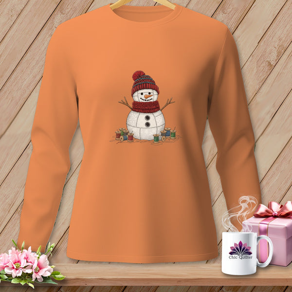 Orange long-sleeve shirt with a quilted snowman graphic and spools of thread.