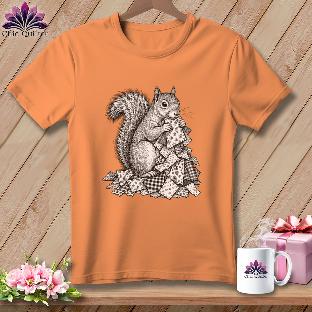 Orange crewneck t-shirt featuring a black and white sketch of a squirrel holding fabric scraps.