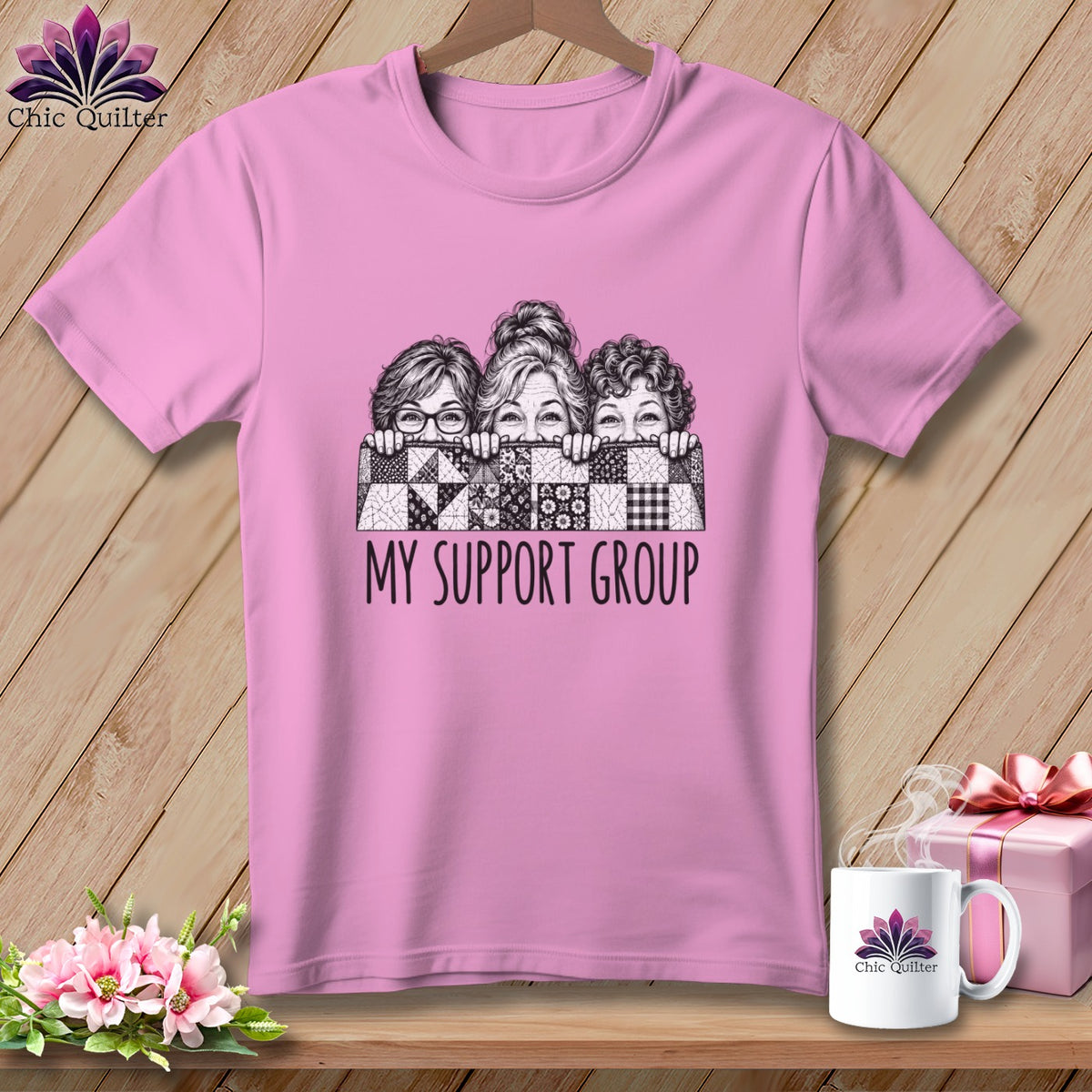 Pink t-shirt with three women peeking over a quilt, text reads "My Support Group".