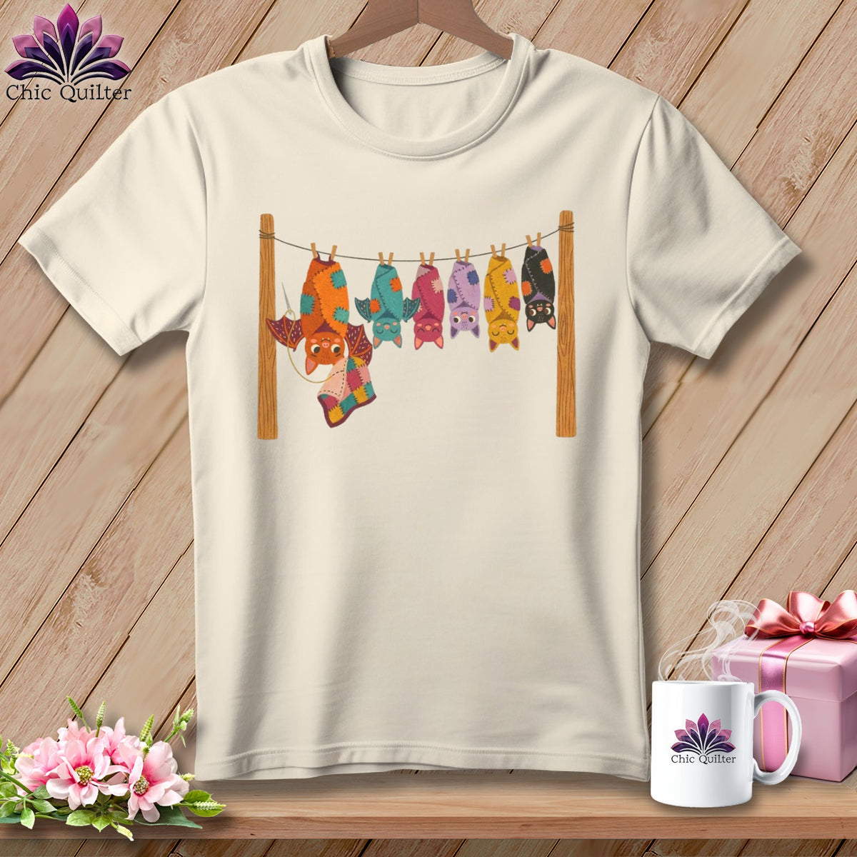 Cream t-shirt with colorful bats hanging on a clothesline with a patchwork quilt.