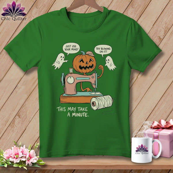 Jack-o'-lantern using sewing machine, with ghosts and text "This may take a minute."