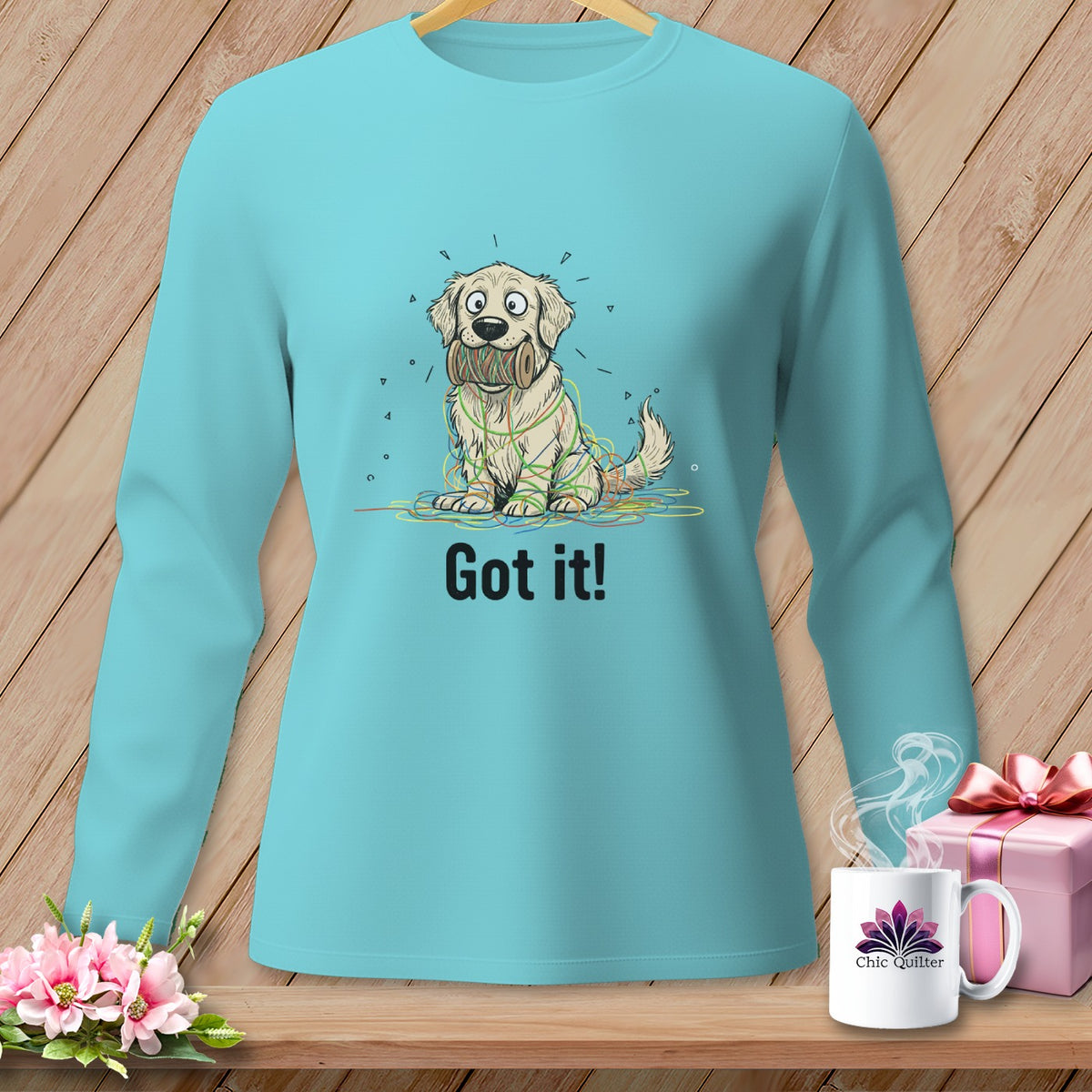 Teal long-sleeve shirt with a cartoon dog tangled in colorful yarn, text "Got it!".
