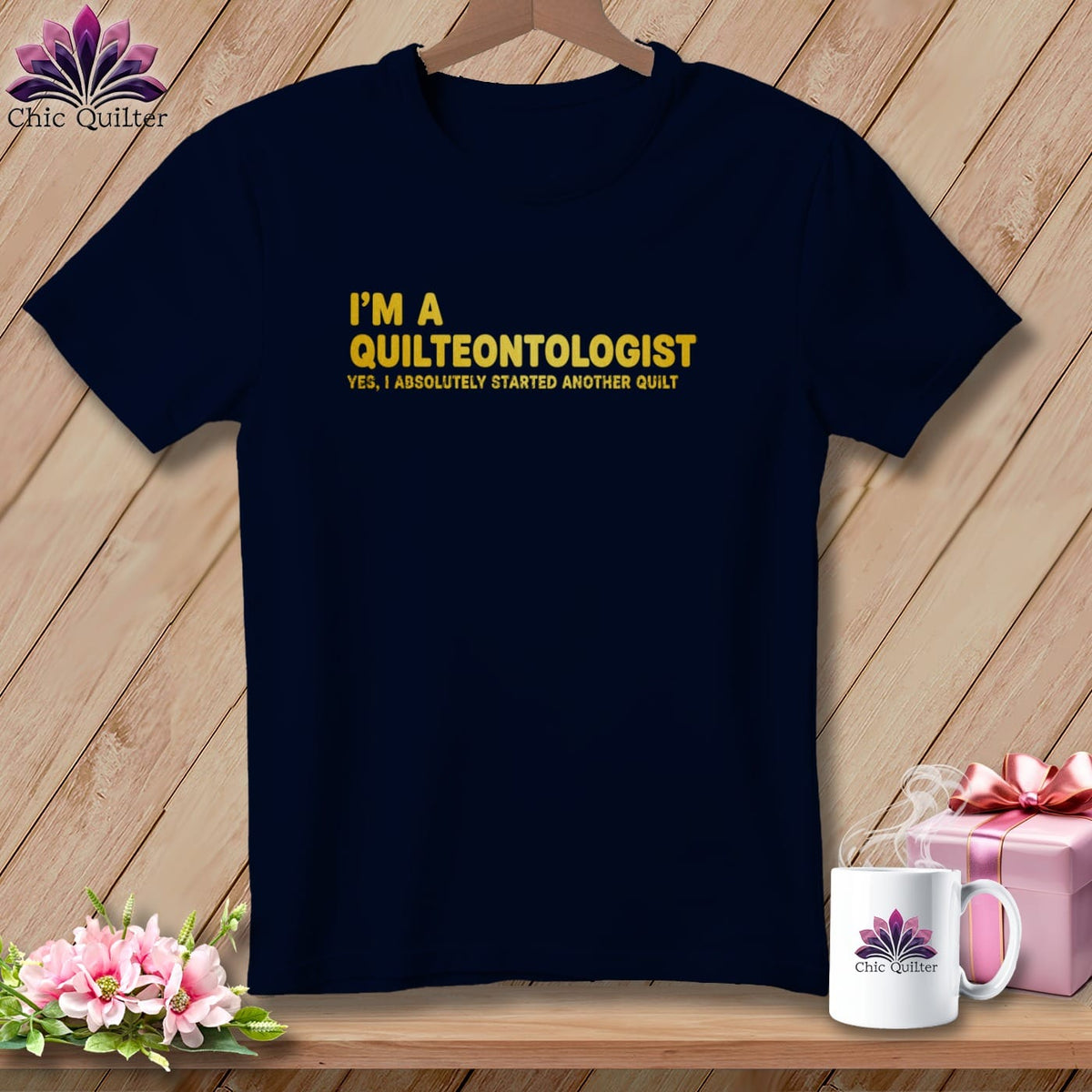 Navy t-shirt with yellow text "I'M A QUILTEONTOLOGIST YES, I ABSOLUTELY STARTED ANOTHER QUILT."