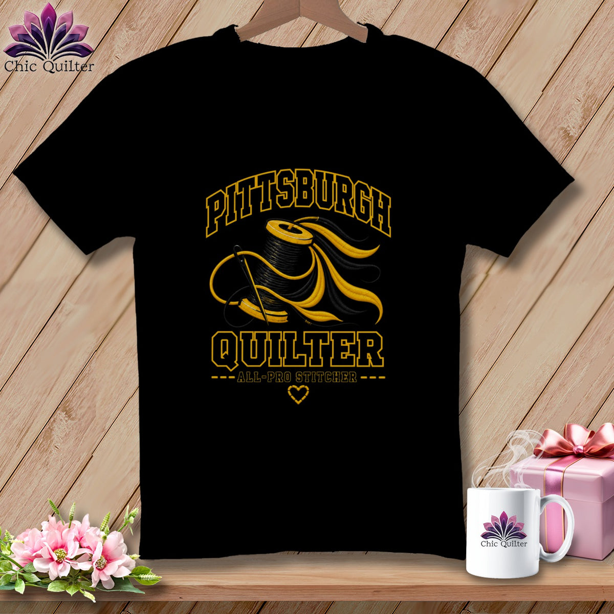 Black t-shirt featuring a yellow and black graphic of a spool of thread, needle, and text reading "PITTSBURGH QUILTER".