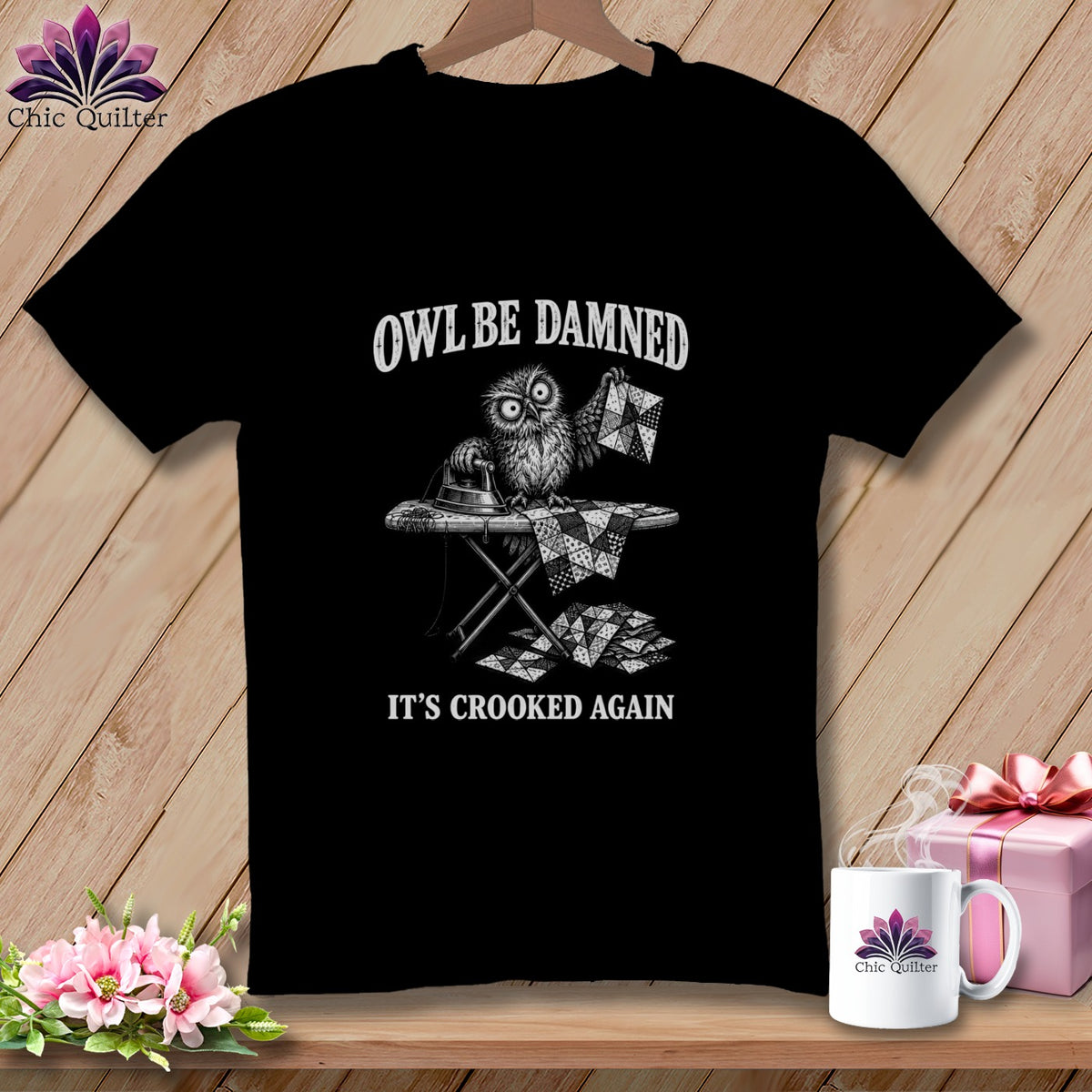 Black t-shirt with an owl ironing a quilt, text reads "OWL BE DAMNED IT'S CROOKED AGAIN".