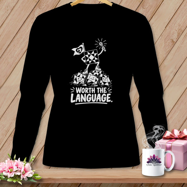 Black t-shirt with a graphic of a quilt block character holding a flag and key.