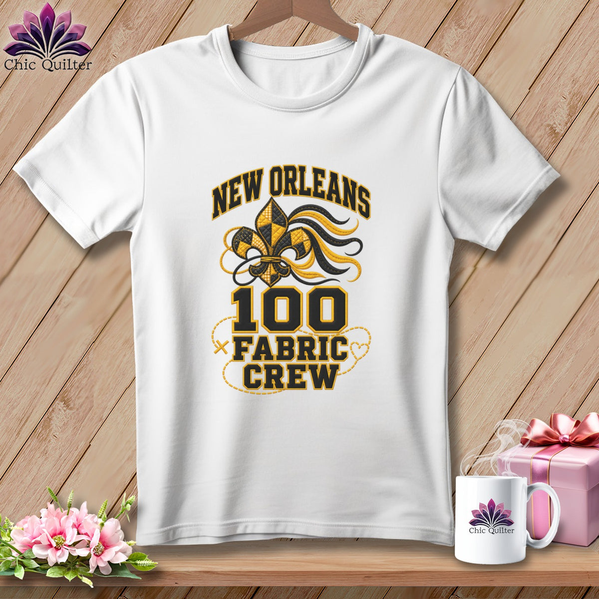 A white t-shirt features a black and yellow New Orleans Fabric Crew design on a wooden background.