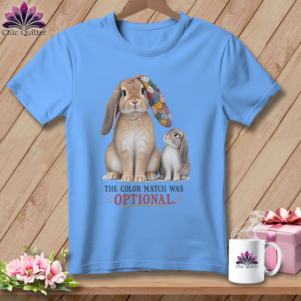 Light blue t-shirt with two rabbits, one wearing a patchwork ear, and text.