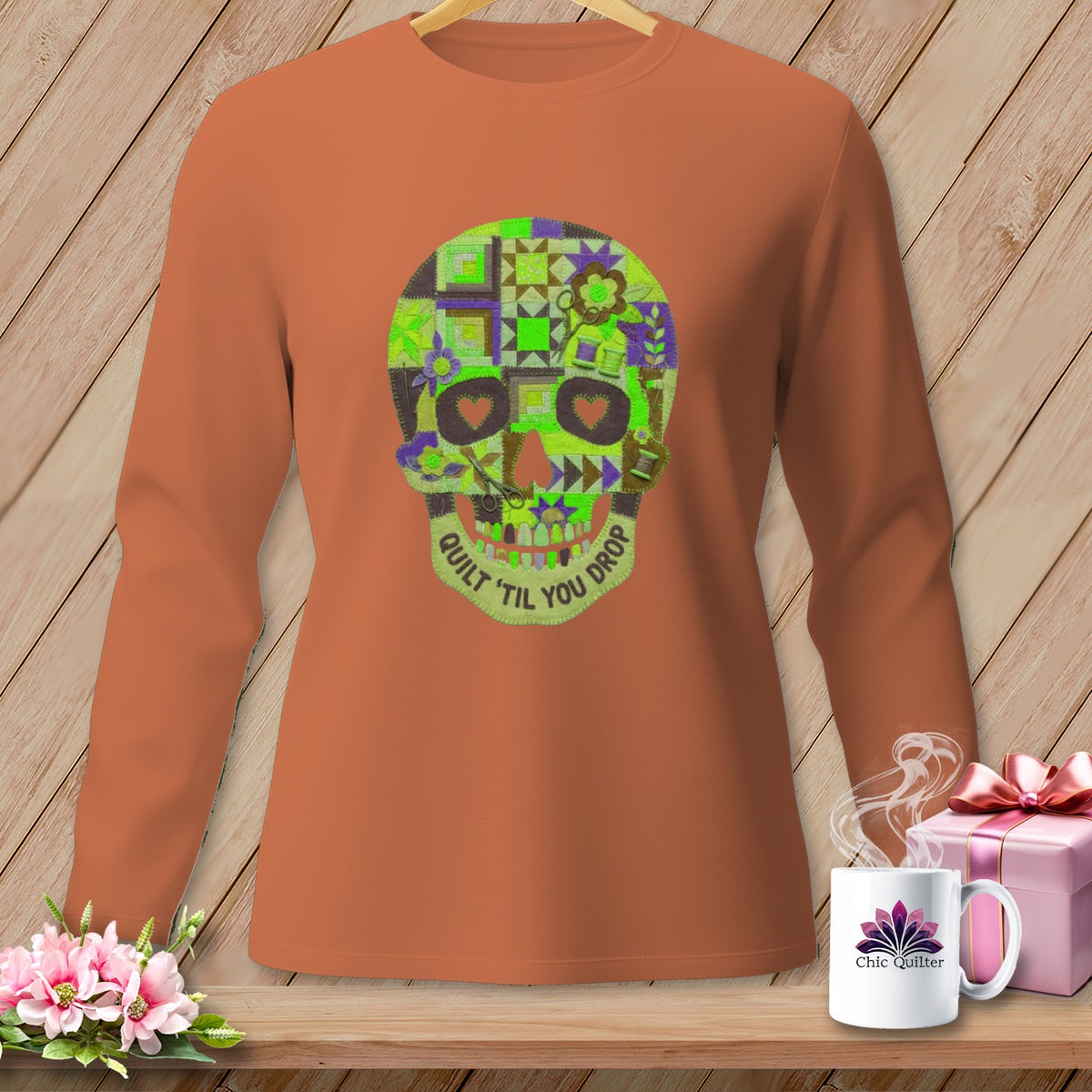 Long-sleeve t-shirt with a patchwork quilt skull design and "Quilt 'til You Drop" text.