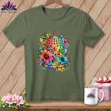 An olive green crewneck t-shirt featuring a colorful watercolor graphic of a floral-embellished thimble on a wooden background.