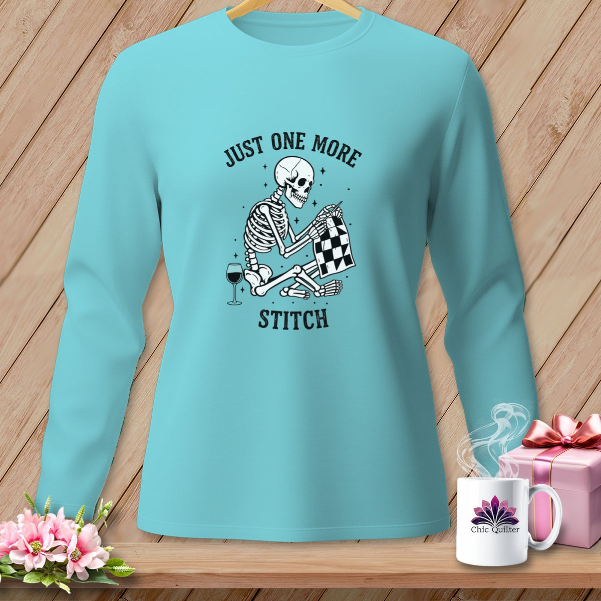 Turquoise long-sleeve shirt with skeleton stitching, text "JUST ONE MORE STITCH".