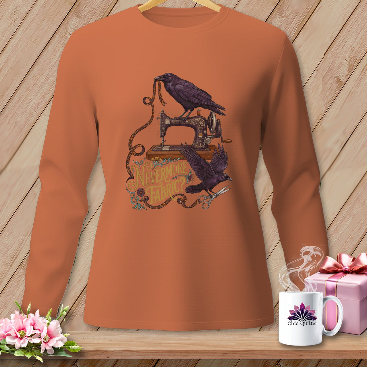Orange long-sleeve shirt with ravens, sewing machine, and text "Nevermore Fabric?".