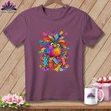 A purple t-shirt featuring a colorful, whimsical bird sitting in a basket of fabric scraps.