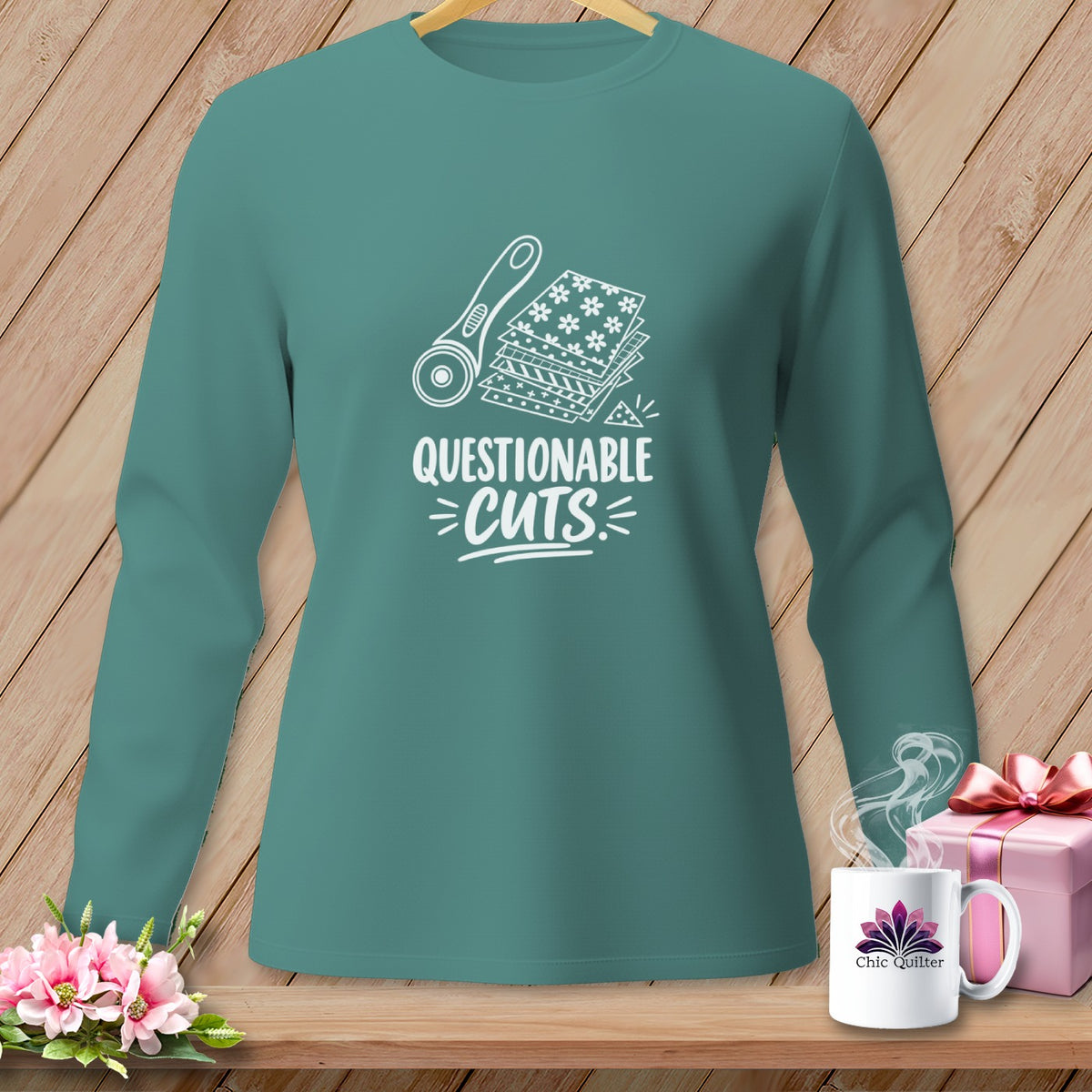 Teal long-sleeve shirt with "Questionable Cuts" and sewing graphic.