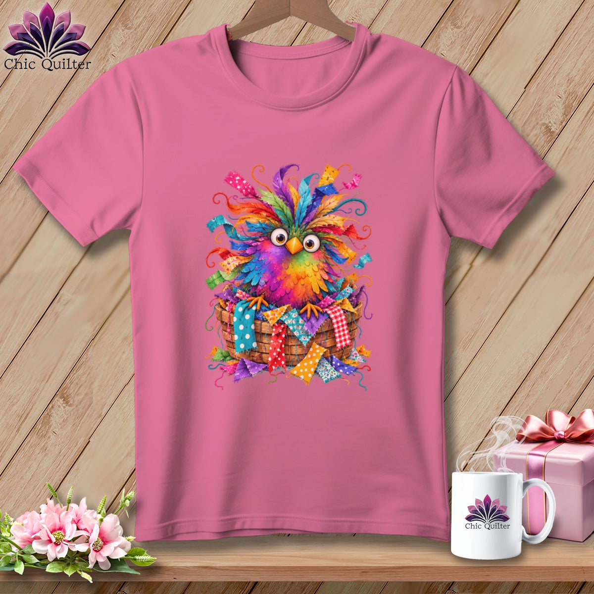 Pink t-shirt featuring a graphic of a colorful, wide-eyed bird sitting in a basket.