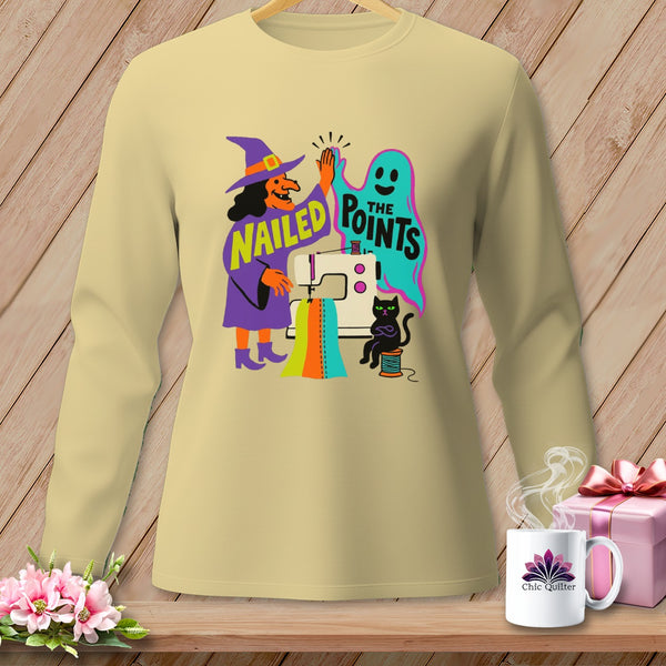 Cream long-sleeve shirt with witch, ghost, sewing machine, and text "Nailed The Points".