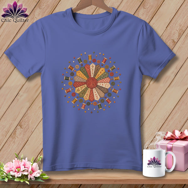 Purple t-shirt with a circular quilt block design and sewing notions.