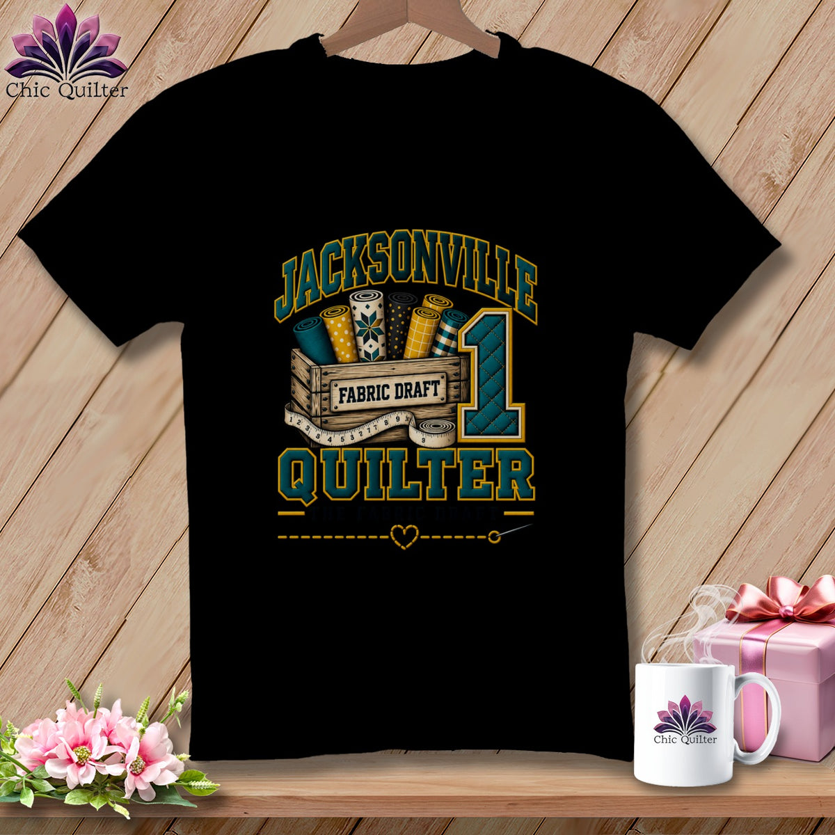 Black t-shirt featuring a Jacksonville Quilter graphic with fabric bolts, a crate, and a large number one.
