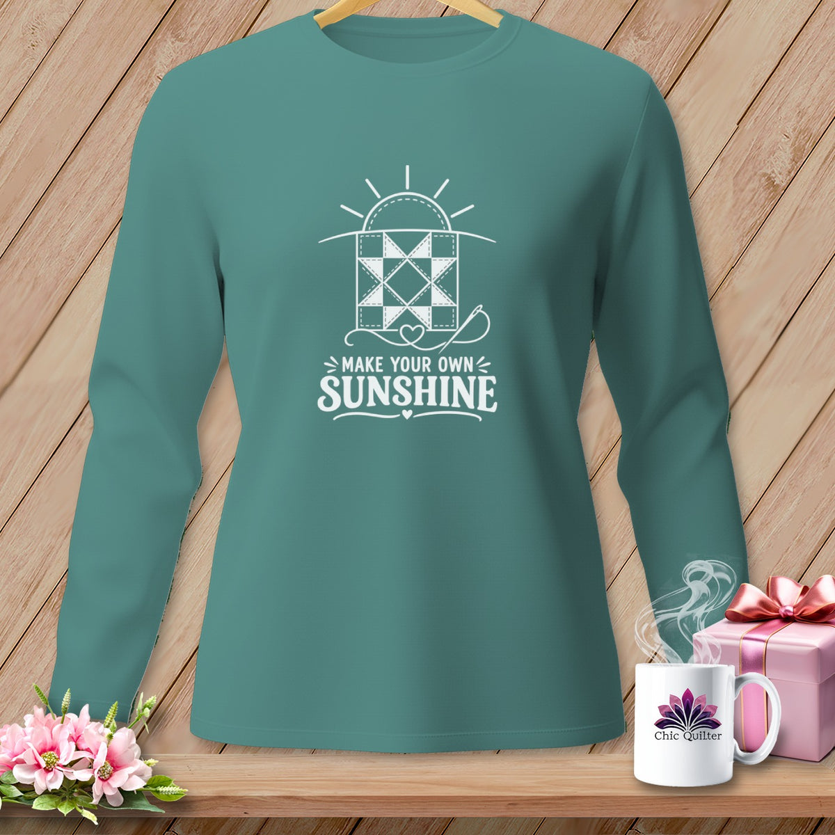 Teal long-sleeve shirt with "Make Your Own Sunshine" quilting graphic and needlework.