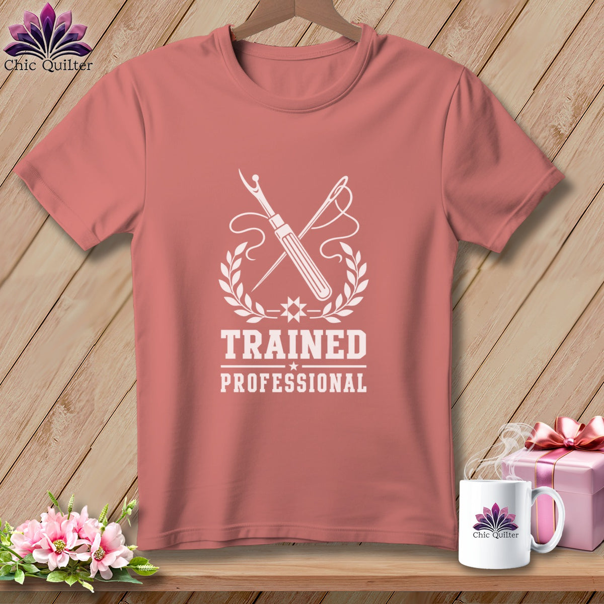 Peach t-shirt with white graphic of sewing tools and "TRAINED PROFESSIONAL" text.