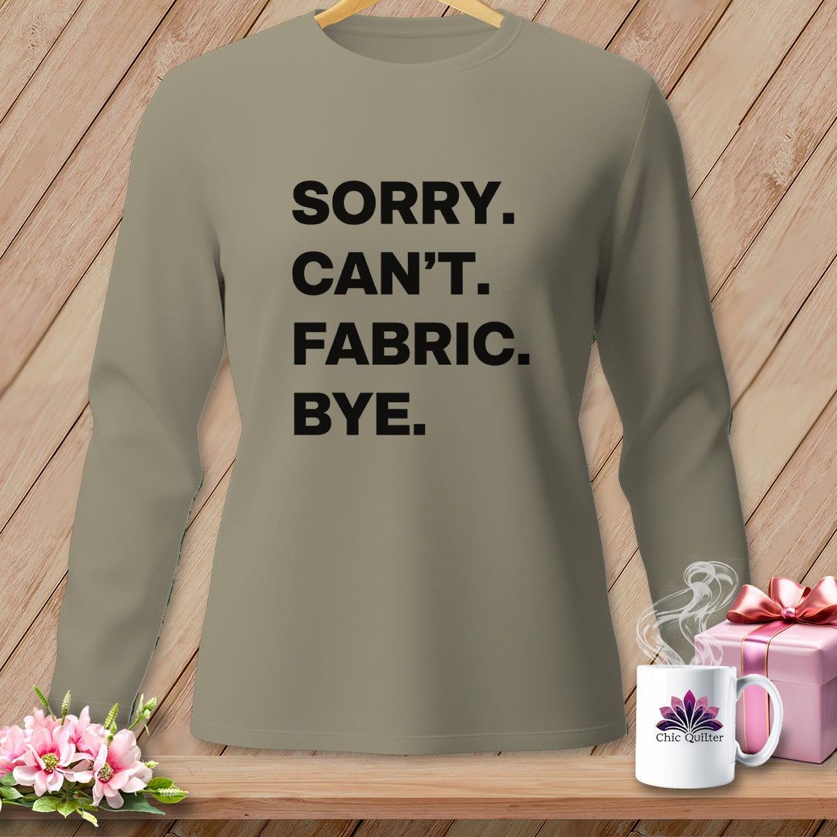 Tan long-sleeve shirt with black text "SORRY. CAN'T. FABRIC. BYE."