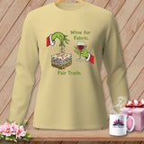 Light yellow long-sleeve shirt with Grinch hands, fabric stack, wine glass, and text 