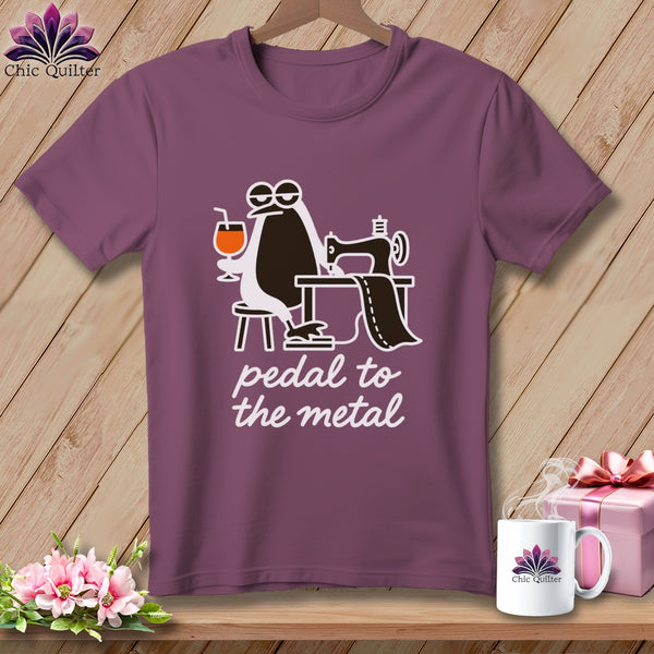 Penguin using a sewing machine with text "pedal to the metal."