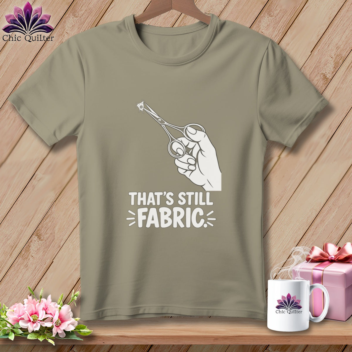T-shirt with hand holding scissors and "That's Still Fabric" text.