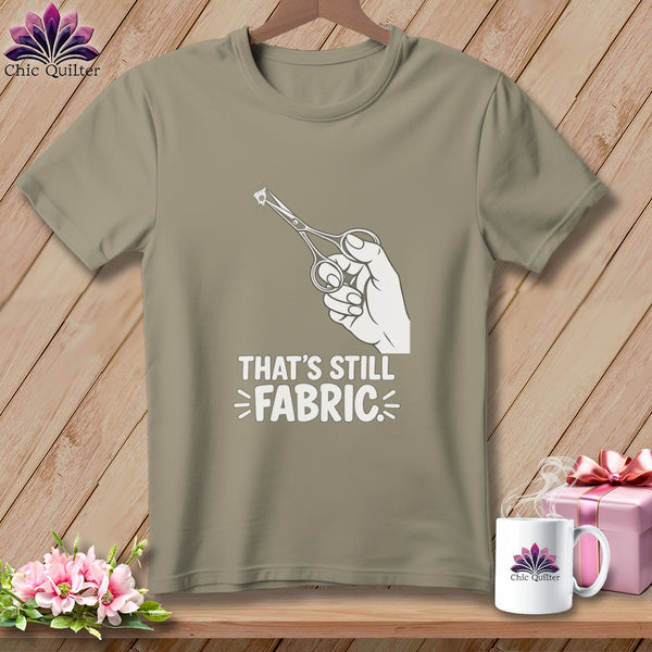 T-shirt with hand holding scissors and "That's Still Fabric" text.