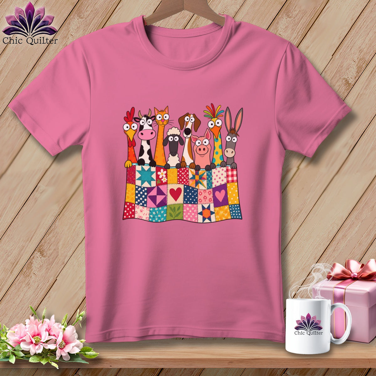 Pink t-shirt with a graphic of cartoon farm animals peeking over a colorful patchwork quilt.