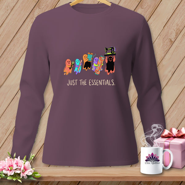 Purple long-sleeve shirt with cartoon ghosts holding sewing essentials and text "JUST THE ESSENTIALS."